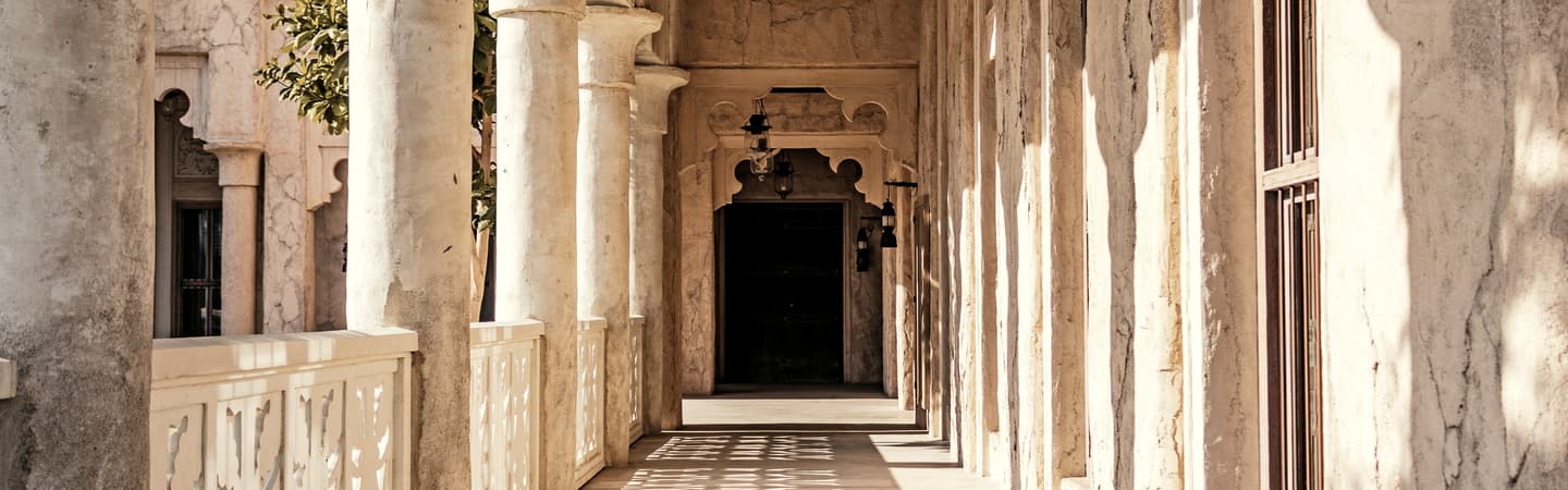 Arched windows along a shaded walkway in old Dubai.