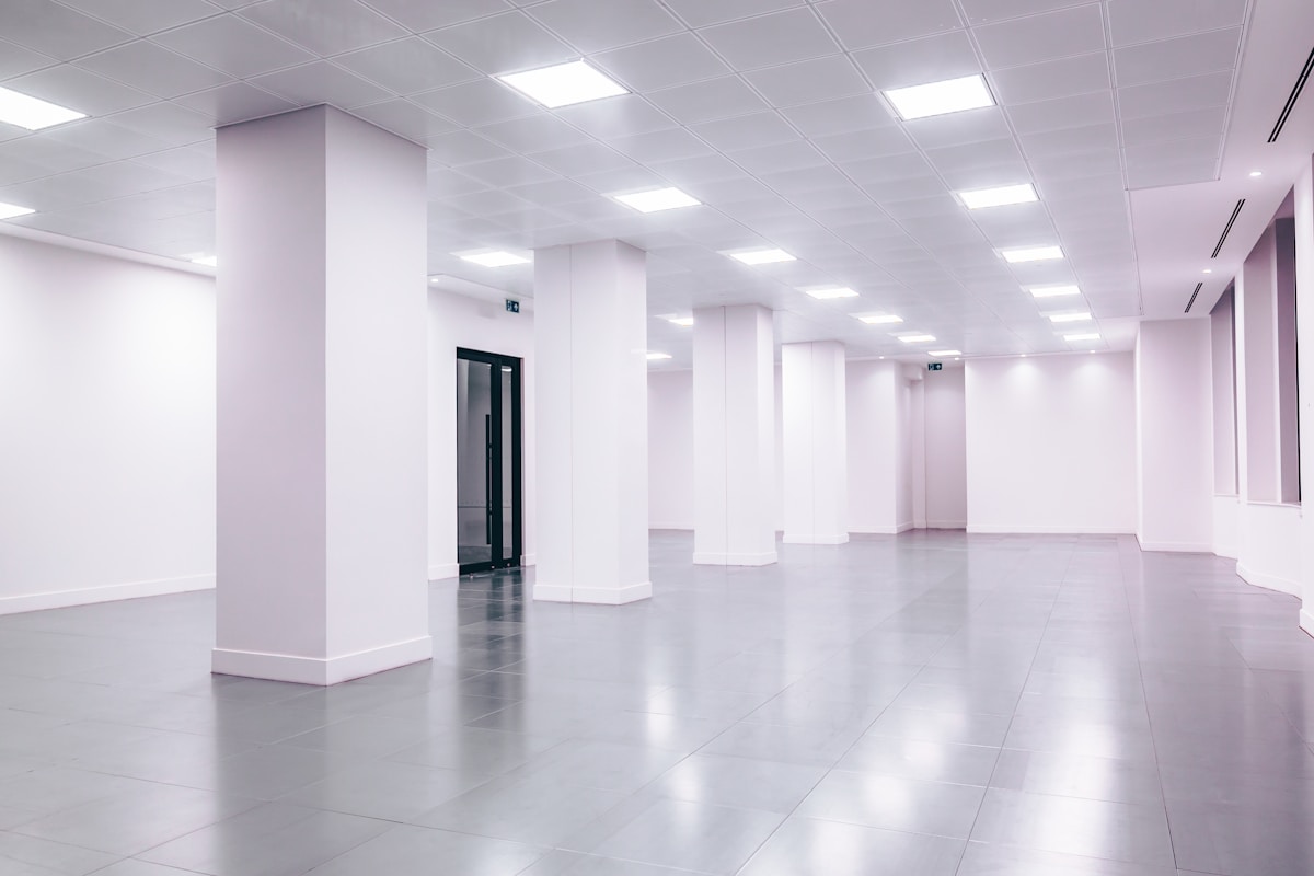 Empty modern office space representing agency scale and headcount versus a single consultant's capacity model